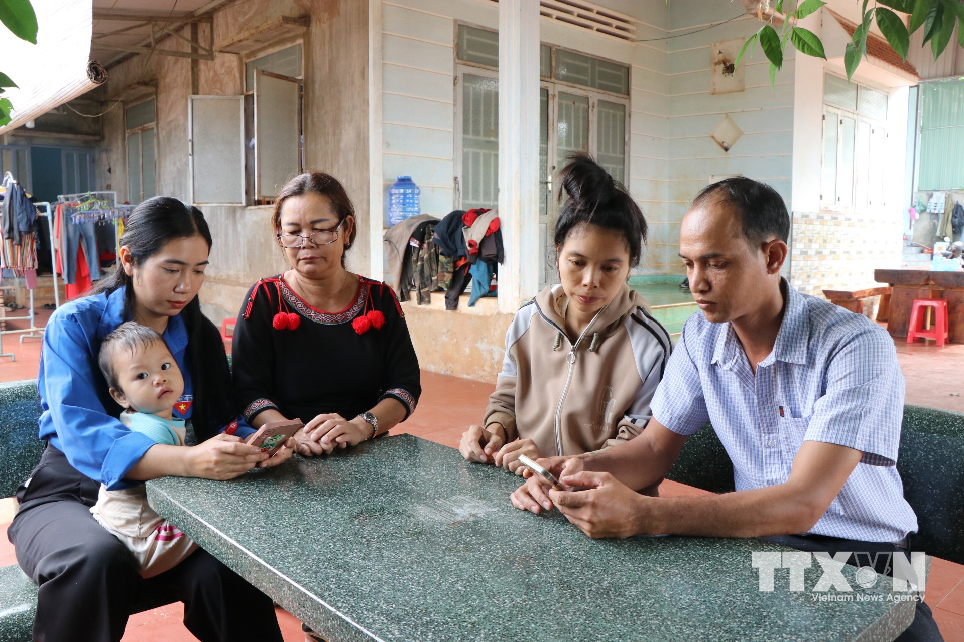 Tổ công nghệ số cộng đồng buôn Hwie, phường Ea Kao (Đắk Lắk) trực tiếp xuống nhà người dân hướng dẫn các dịch vụ công. (Ảnh: Nguyên Dung/TTXVN)